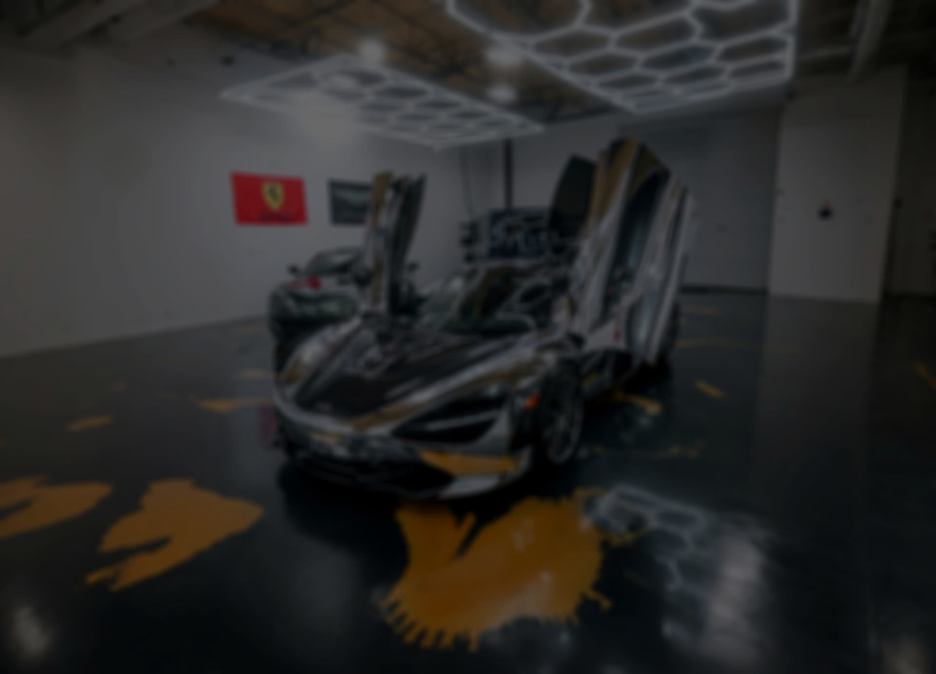 McLaren with doors up inside the shop